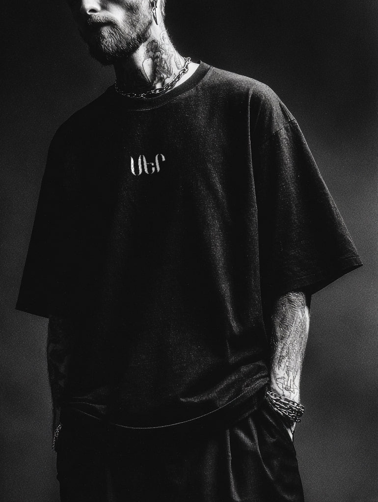 Person wearing a black t-shirt with 'ՍԵՐ' logo against a dark background