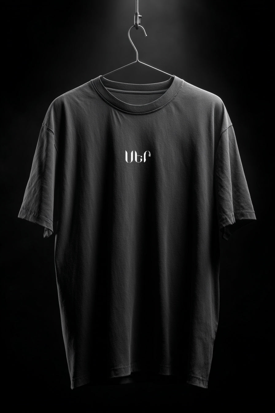 Black t-shirt with a logo on a hanger against a black background